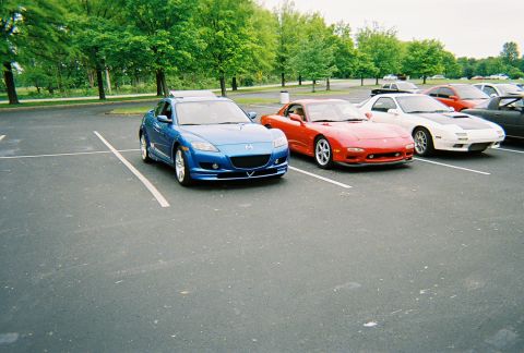1991 Ford Probe - Multiple sports cars are parked in an outdoor lot on a cloudy day.