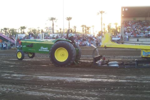 1994 Ford F-150 - A tractor competes in a pull event with spectators in the background.