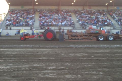 1994 Ford F-150 - Tractor competes in a pull event with a sled and crowd in attendance.