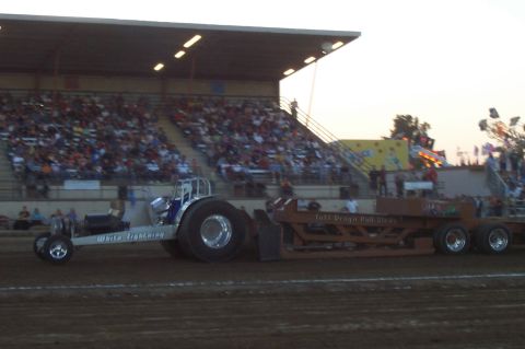 1994 Ford F-150 - A tractor puller named 'White Lightning' competes with a large trailer in front of a crowd.