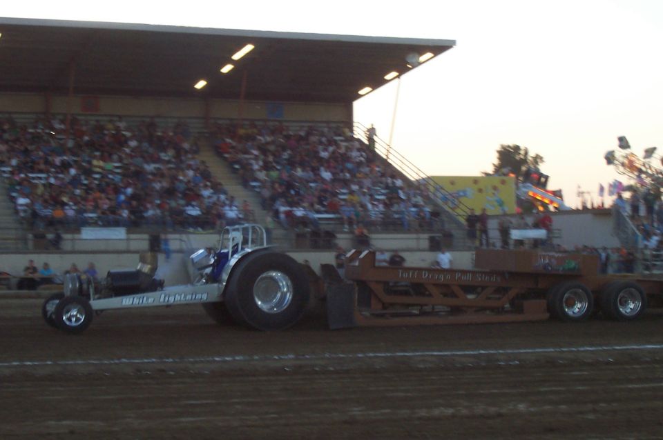 White Lightning tractor puller with a large trailer, side view, at a competition