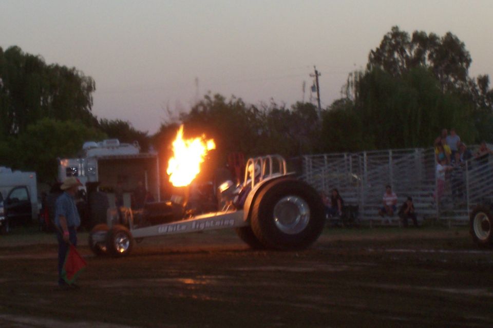 Dragster with flames erupting from exhaust, side view. Text on side reads "White Lightning"
