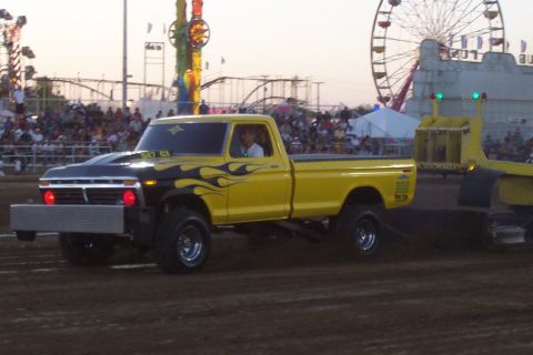 1994 Ford F-150 - Modified pickup truck with flame decals at a fairground event.
