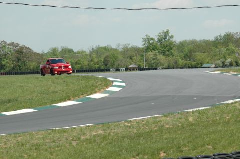 1993 Ford Mustang - A red pickup truck navigates a turn on a race track.