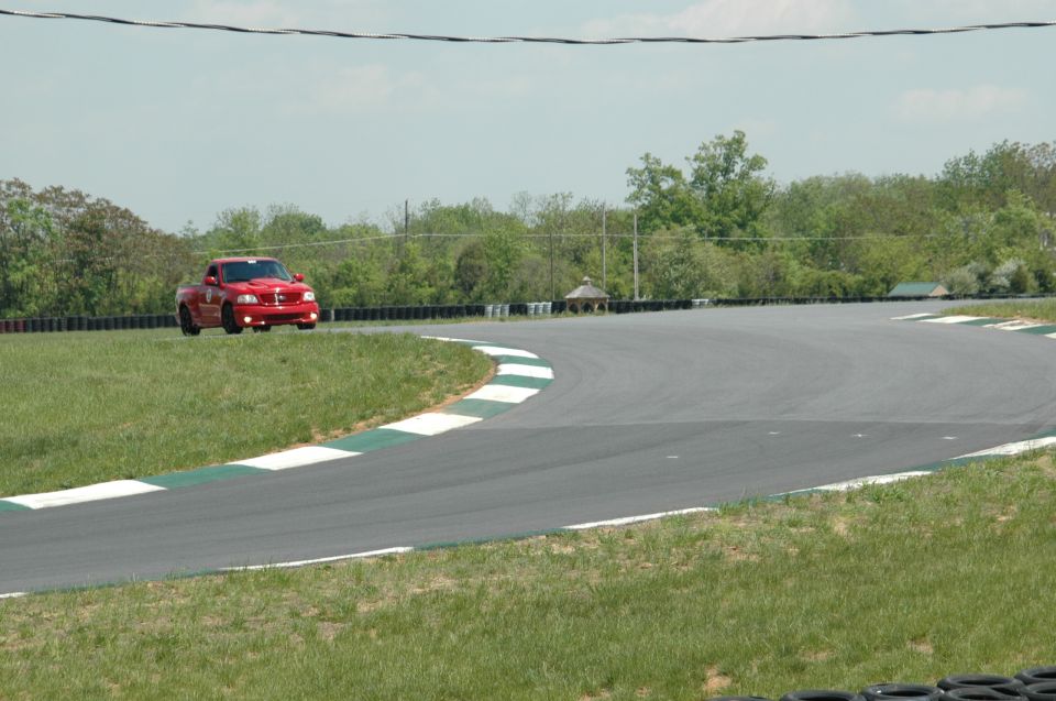 Red pickup truck on race track, front view