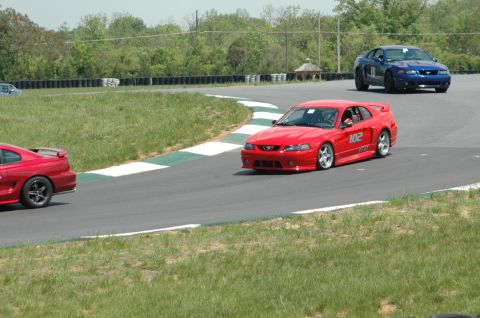 1993 Ford Mustang - Two Ford Mustangs, a red one and a blue one, compete on a race track.
