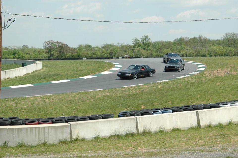 Black 1993 Ford Mustang on race track, 3q-front view