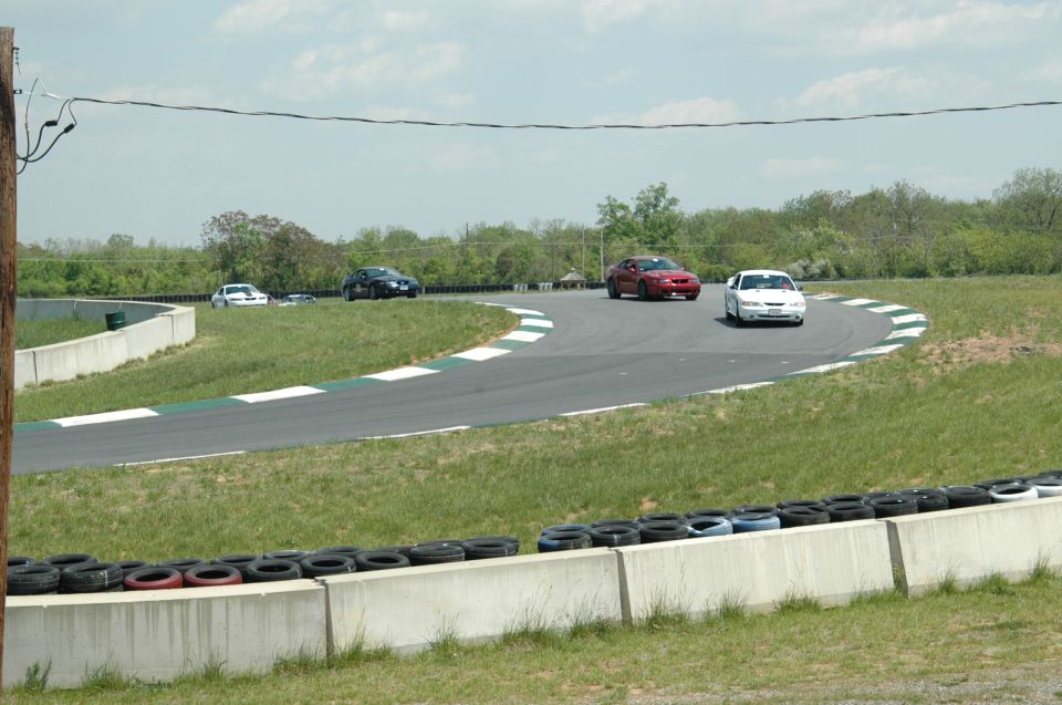 Cars on a race track with tire barriers and grass