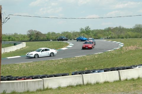 1993 Ford Mustang - Multiple cars race on a track, with a white Mustang in the foreground.