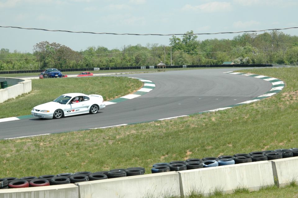 White coupe with GT-40 decal on race track, side view