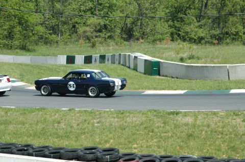 1993 Ford Mustang - A classic Ford Mustang race car with number 84 competes on a sunny day at a track.