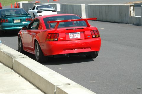 1993 Ford Mustang - Red Mustang Cobra SVT with a large rear spoiler and custom 'COBRAR' license plate.