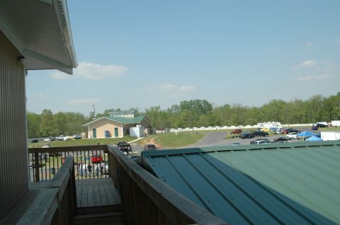 1993 Ford Mustang - A wide view of a parking area with several cars and buildings, under a bright blue sky with scattered clouds.