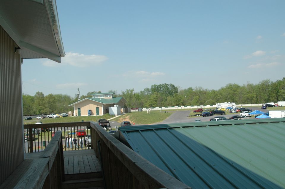 Parking lot scene with multiple vehicles and buildings under a clear sky