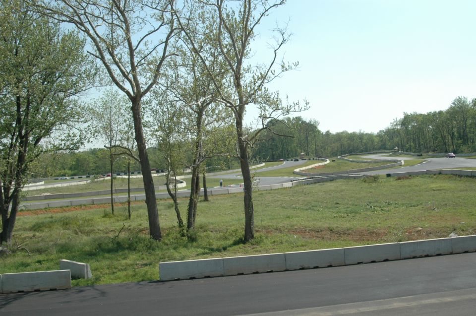 Race track winding through trees, with several cars visible on the track