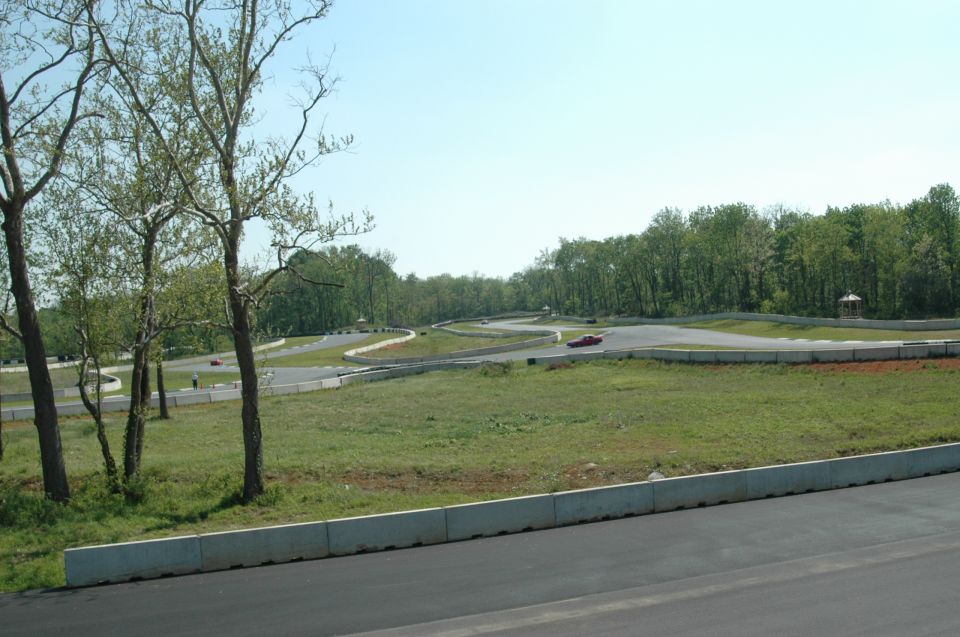 Cars on a winding race track with trees and a clear sky