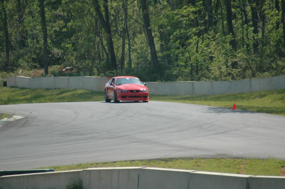 Red Ford Mustang on a race track, front view