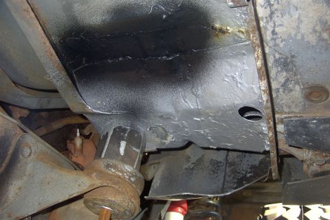 1994 Ford Bronco - Close-up view of the undercarriage of a vehicle, revealing suspension parts and frame structure.