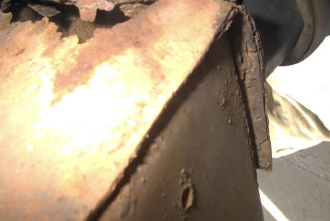 1994 Ford Bronco - Detail of heavily rusted metal, likely from the undercarriage of a vehicle, with a Supermotors.net watermark.