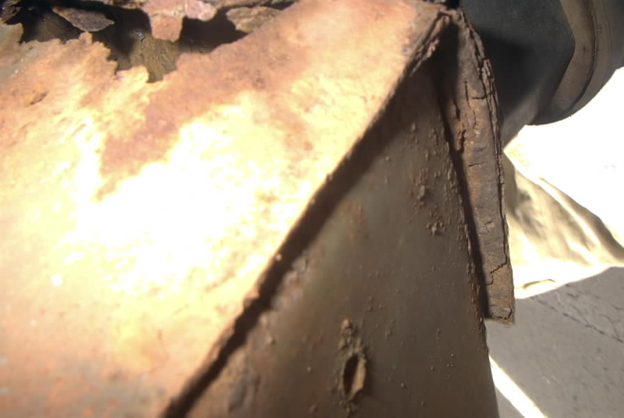 Close-up of rusted metal frame with Supermotors.net logo