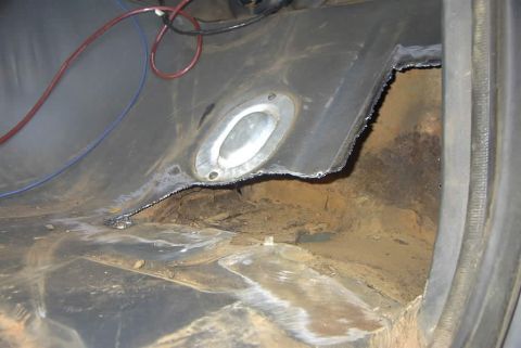 1994 Ford Bronco - The interior floor shows extensive rust and damage, with metal cut away to reveal the undercarriage.