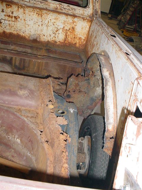1972 Ford Ranchero - Extensive rust damage is visible in the wheel well and bed area of this vehicle, with a spare tire partially obscured.