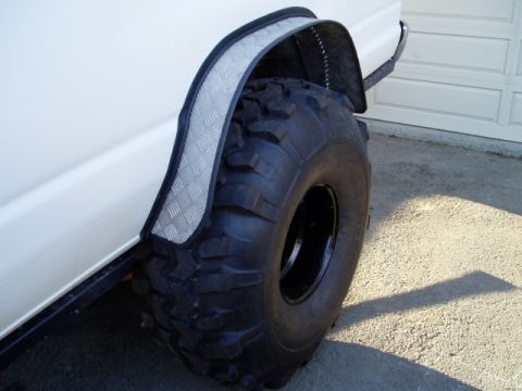 2000 Ford E350 - This van features a large off-road tire and a custom diamond plate fender flare, suggesting modifications for off-road use.
