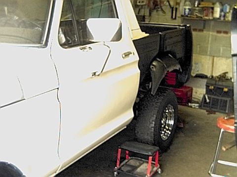 1978 Ford Bronco - This 1978 Ford Bronco is shown from the side, its white cab and black truck bed with custom wheels.