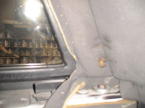 1993 Ford C-350 (Centurion Conversions) - Close-up of vehicle interior trim and a window showing a reflection of a shelf stocked with jars.
