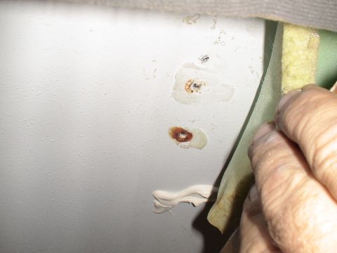 1993 Ford C-350 (Centurion Conversions) - Close-up of an interior panel showing signs of rust and a recent repair with putty.