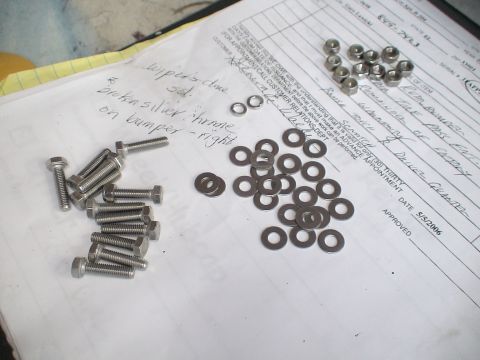 1993 Ford C-350 (Centurion Conversions) - Hardware and paperwork, including notes about a broken silver chrome bumper, are laid out on a surface.