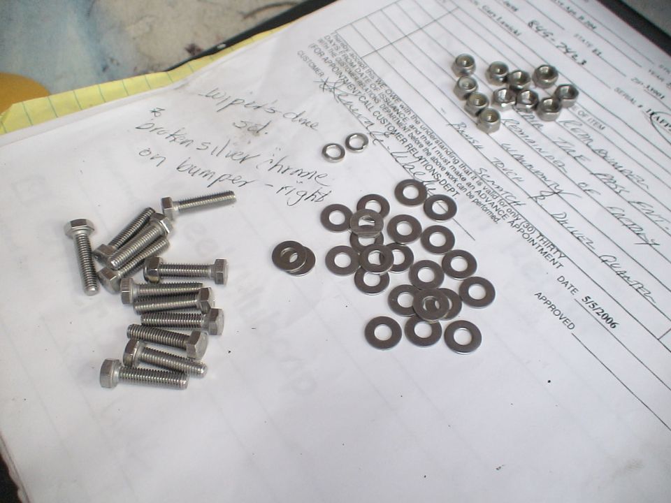 Bolts, washers, and nuts scattered on a document with handwritten notes