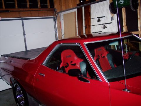 1972 Ford Ranchero - This red coupe utility vehicle, likely from the early 1970s, features racing seats and a covered bed.