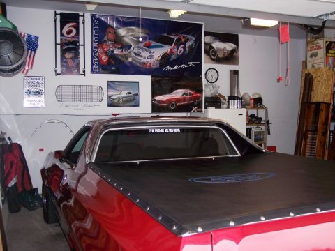 1972 Ford Ranchero - A red 1972 Ford Ranchero is parked in a garage, covered with a black tonneau cover.