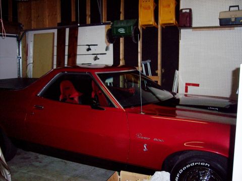 1972 Ford Ranchero - A red 1972 Ford Ranchero with a black hood sits in a garage.