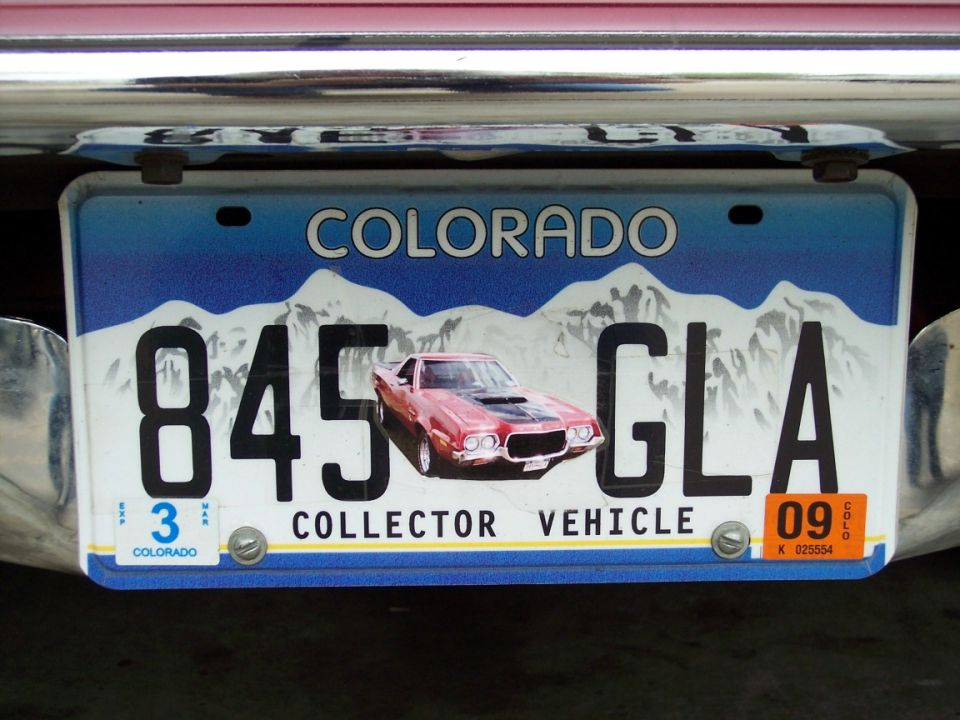 Colorado Collector Vehicle license plate 845 GLA with red car graphic in chrome frame