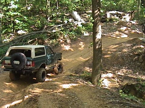 1996 Ford Bronco - This 1996 Ford Bronco tackles a challenging off-road course, kicking up dirt as it climbs the trail.