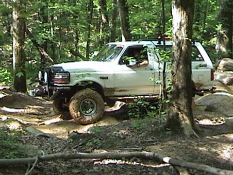 1996 Ford Bronco - This 1996 Ford Bronco navigates a challenging off-road course with mud and rocks.