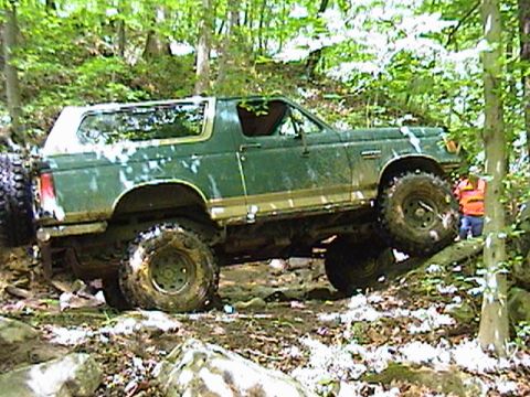 1996 Ford Bronco - Ford Bronco tackling an off-road trail with steep inclines and obstacles.