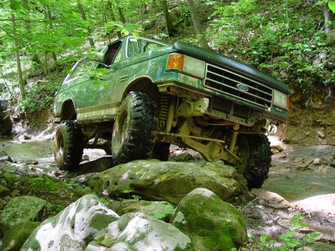 1996 Ford Bronco - This lifted green Ford Bronco navigates a challenging rocky stream bed during an off-road excursion.
