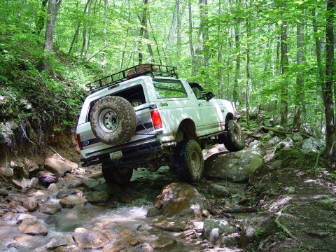 1996 Ford Bronco - This 1996 Ford Bronco is shown tackling a challenging off-road trail through a wooded area.