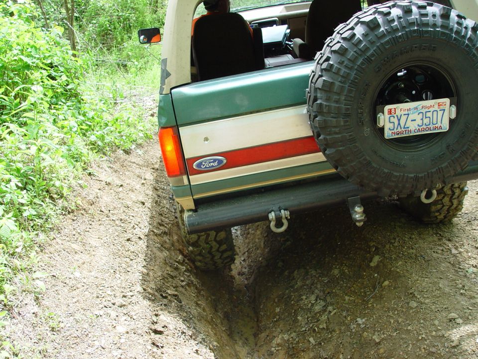 1996 Ford Bronco rear view on muddy trail with spare tire mounted