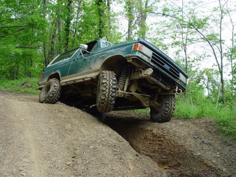 1996 Ford Bronco - Ford Bronco navigates challenging off-road terrain on a dirt hill.