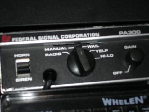 1999 Ford Crown Victoria - Close-up of a Federal Signal PA300 siren control unit, showing various function selectors and controls.
