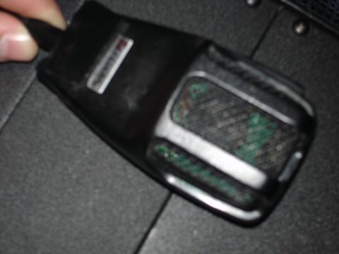 1999 Ford Crown Victoria - Close-up of a black microphone with a silver badge, held by a person's fingers.