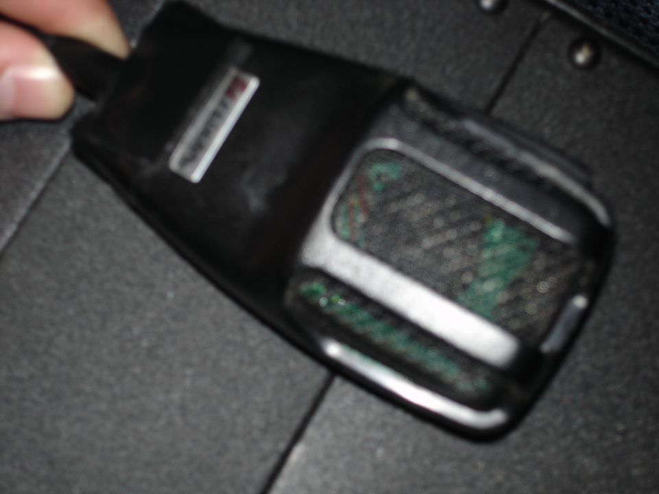 Black microphone with a silver badge on top, held by a hand