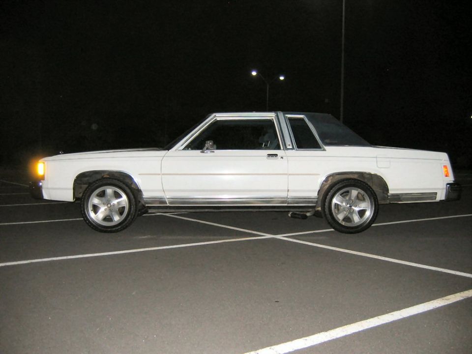 White two-door Ford coupe in side profile at night with alloy wheels