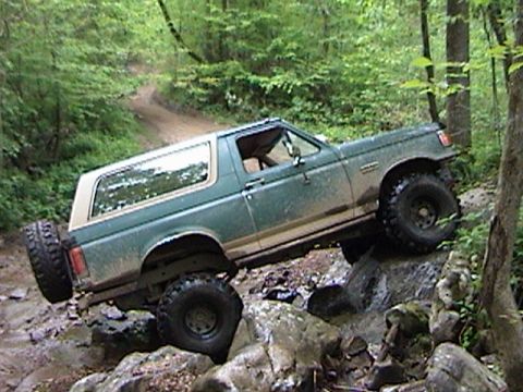1996 Ford Bronco - This Ford Bronco is navigating a rocky trail, with its tires on large stones.