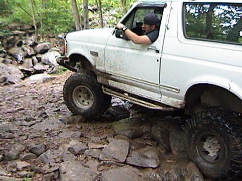 1996 Ford Bronco - White 1996 Ford Bronco tackling a challenging rocky terrain.