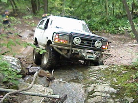 1996 Ford Bronco - This modified Ford Bronco navigates a challenging off-road course through a wooded area.